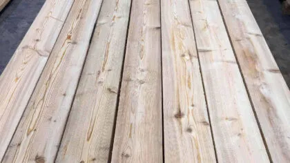 Assi di legno chiaro affiancate, con nodi in evidenza